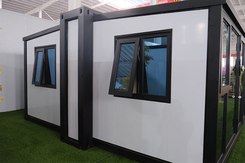 Modular building pods with windows on a green carpeted floor.