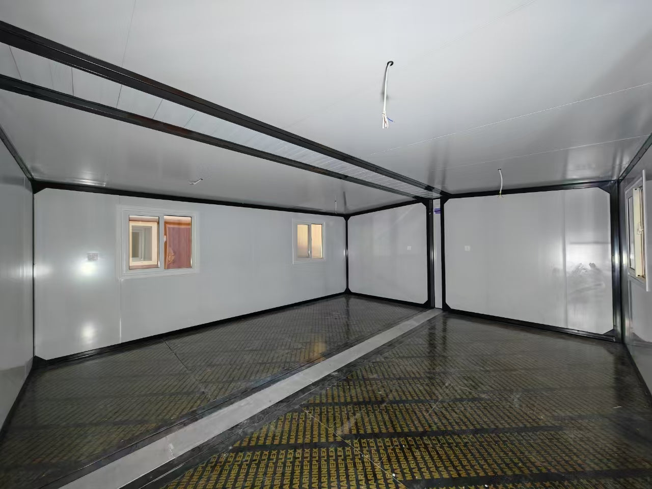 Empty room with white walls and a reflective floor