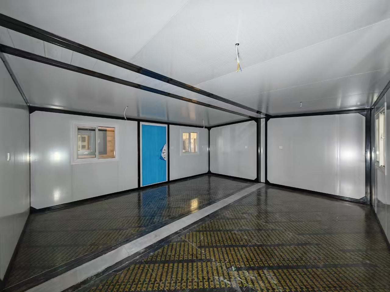 Interior of a mobile home with a blue door and white walls.