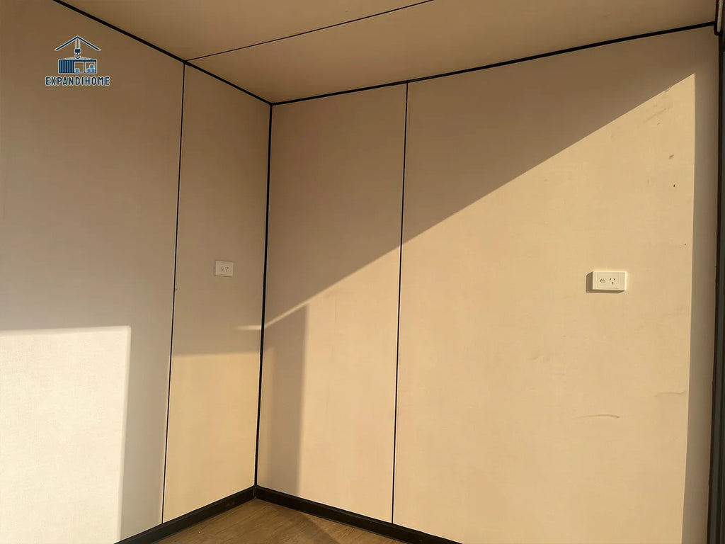Beige wall panels in a corner with shadows cast by the panels.