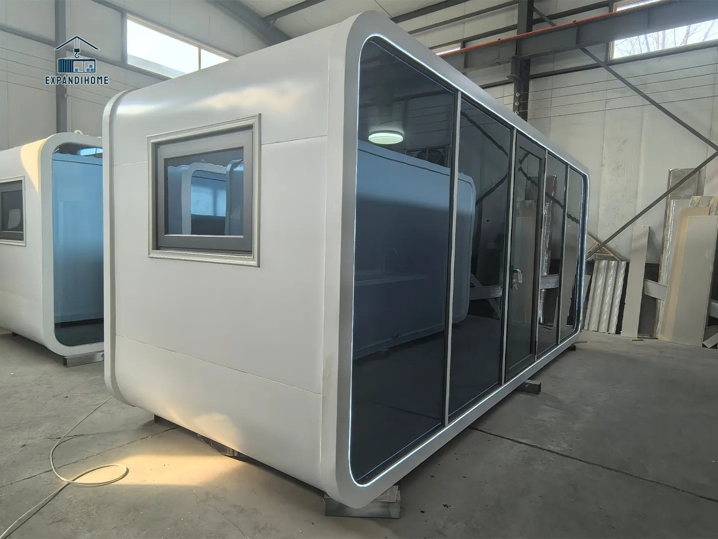 Modular office pod with glass walls in a warehouse setting