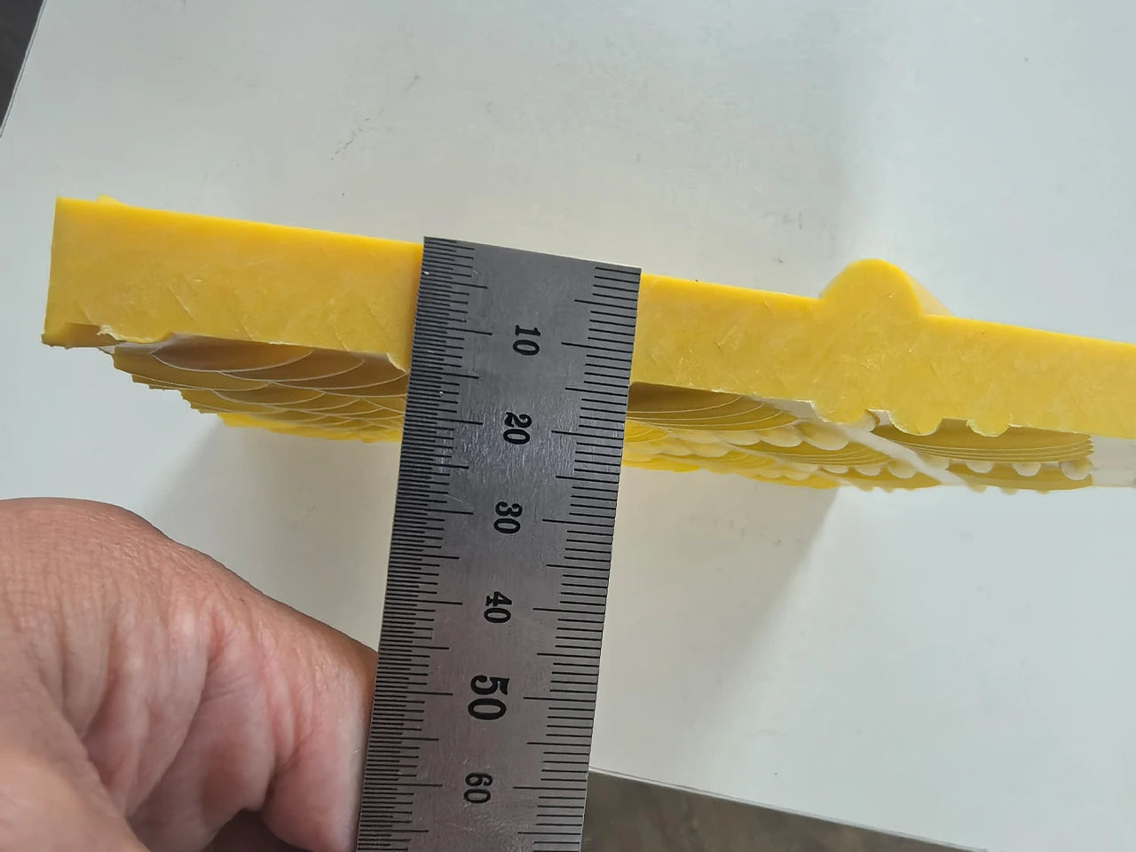 Yellow foam block with a ruler for scale on a white background HDPE ROAD MATS 5