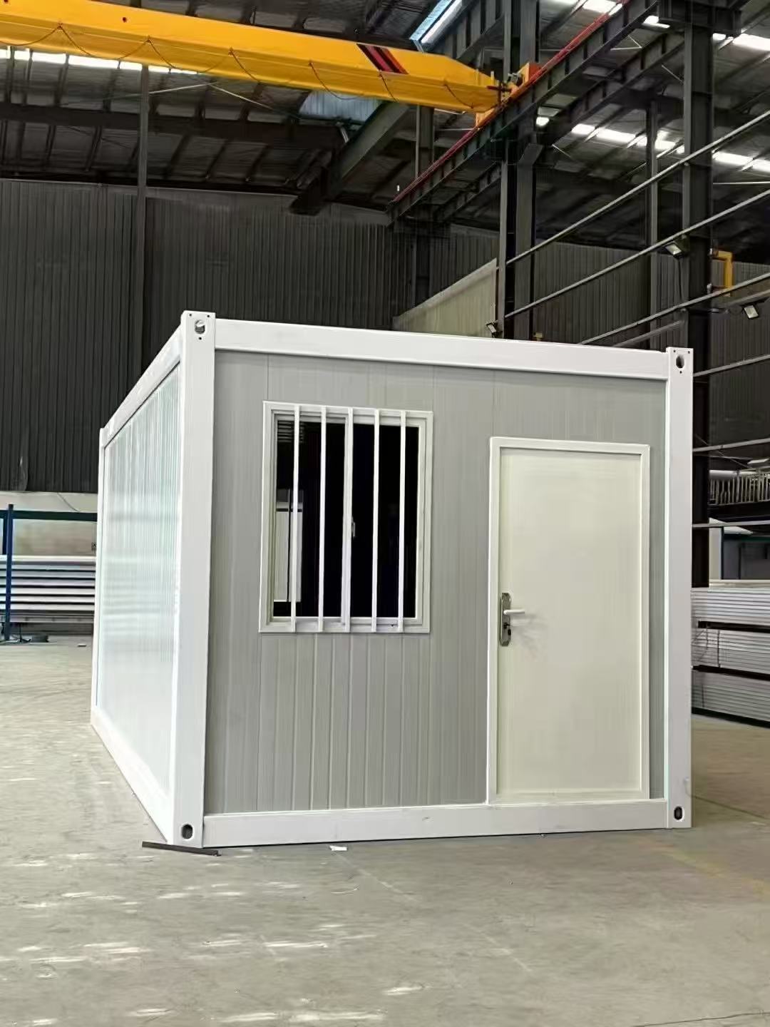 Modular building container with a door and window in an industrial setting