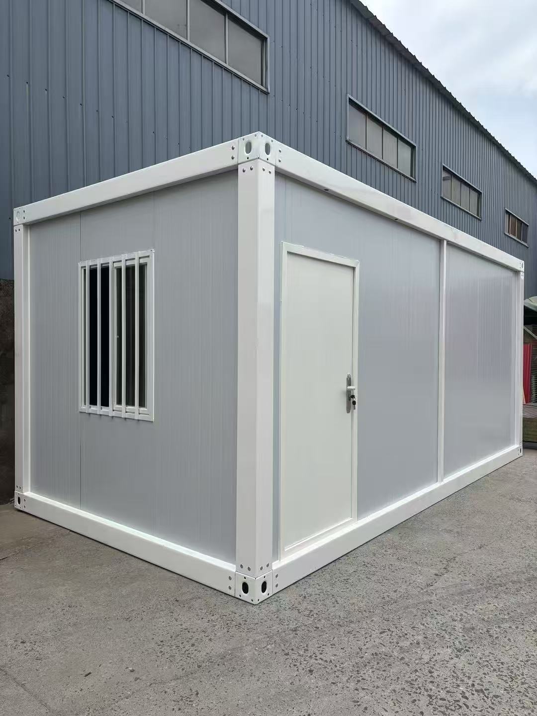 Modular building container with a door and window on a concrete surface.