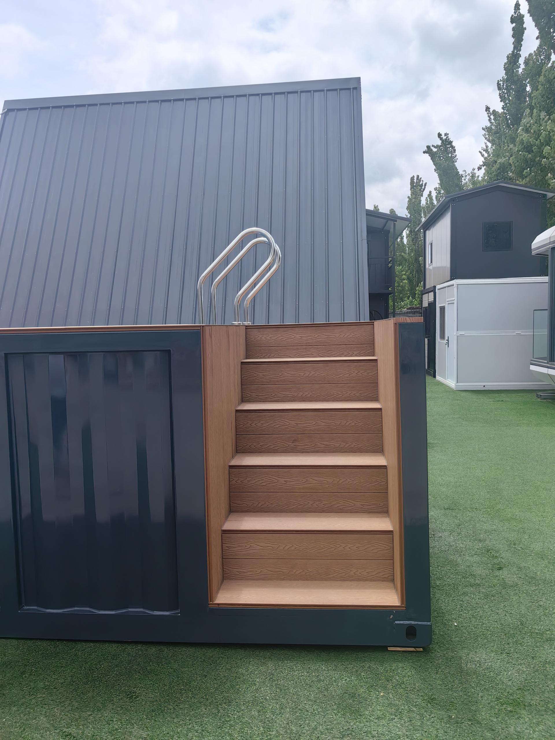 Small building with wooden steps leading up to a door on a grassy area