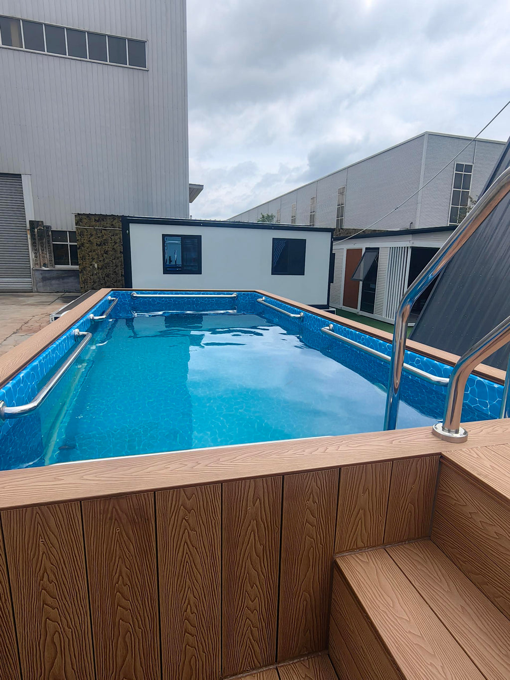 Swimming pool with wooden deck area in an industrial setting