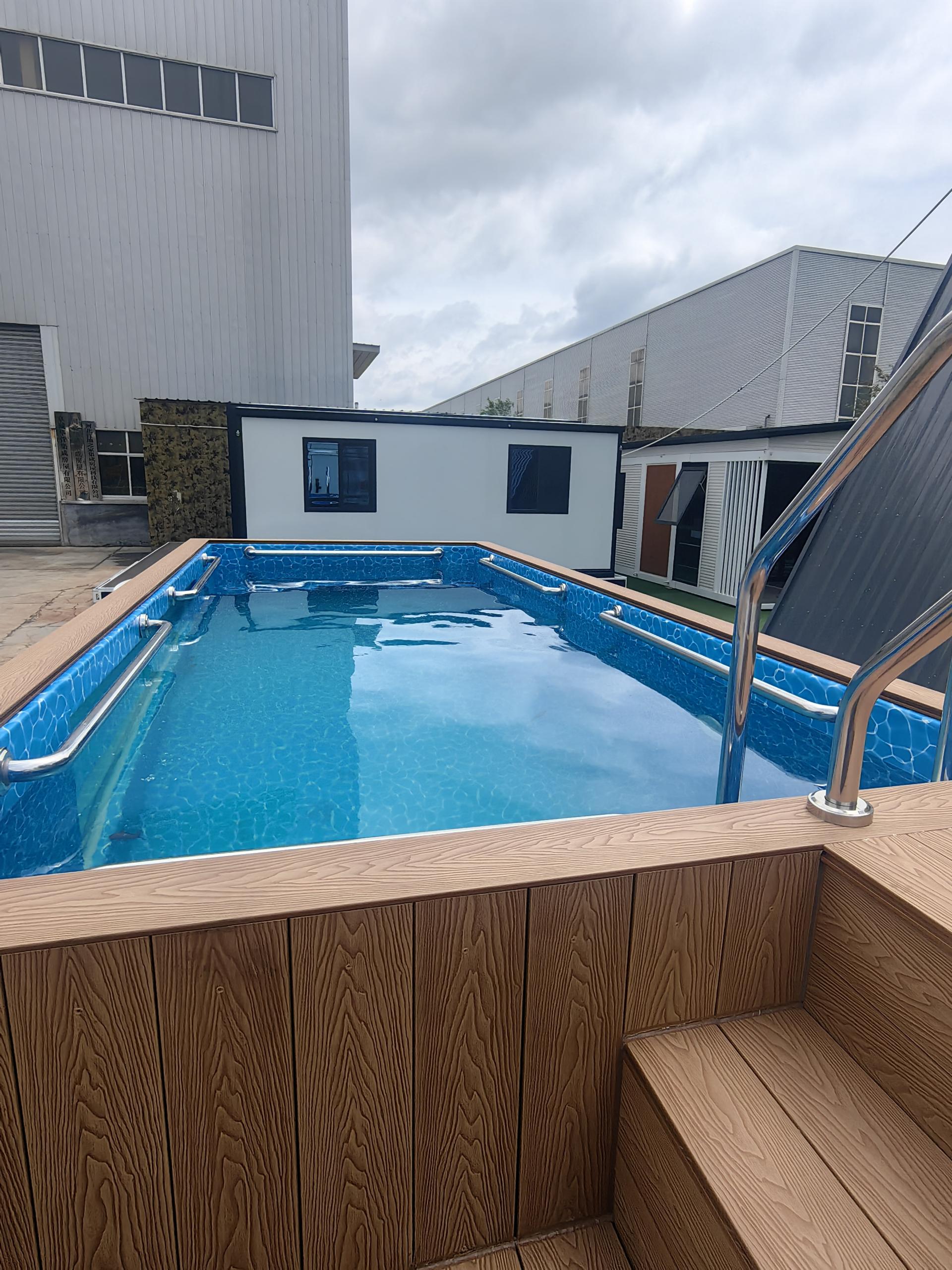 Swimming pool with wooden deck area in an industrial setting