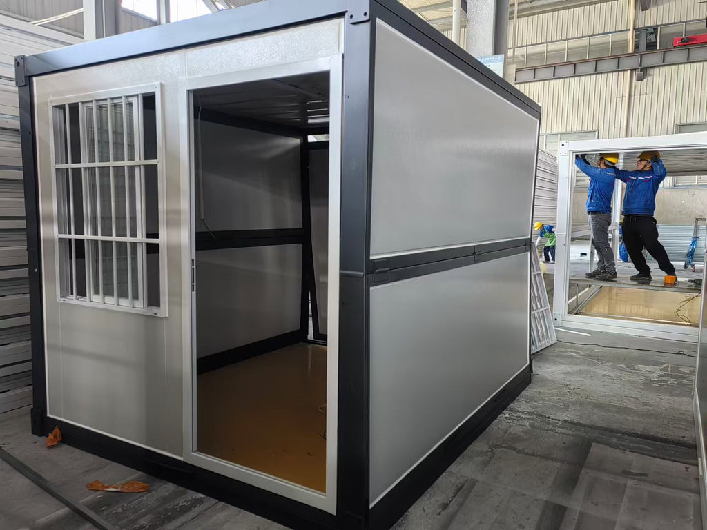 Modular metal building with open door, workers in the background