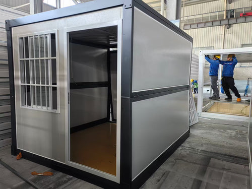 Modular metal building with open door, workers in the background