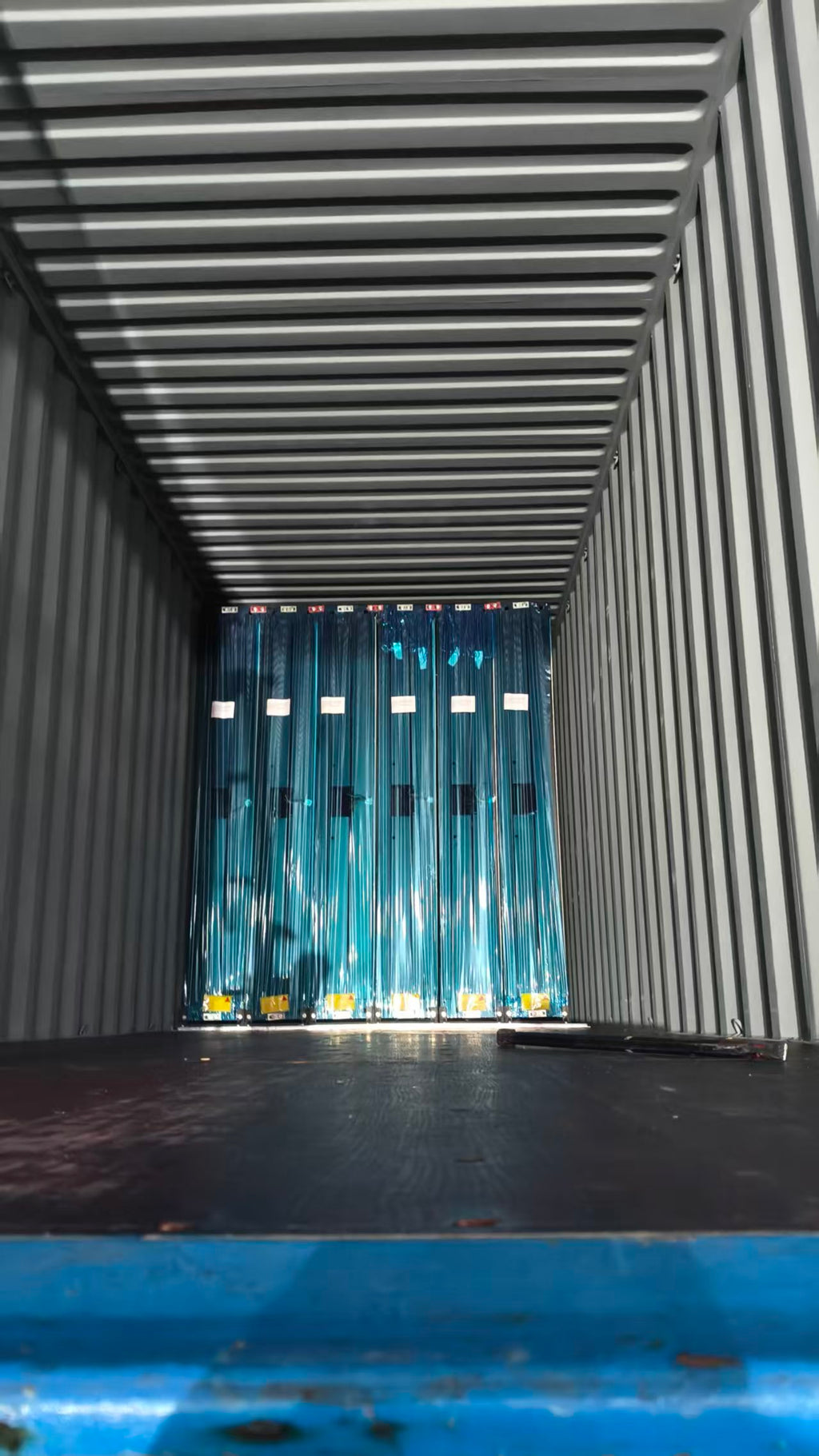 Open shipping container with blue curtains inside