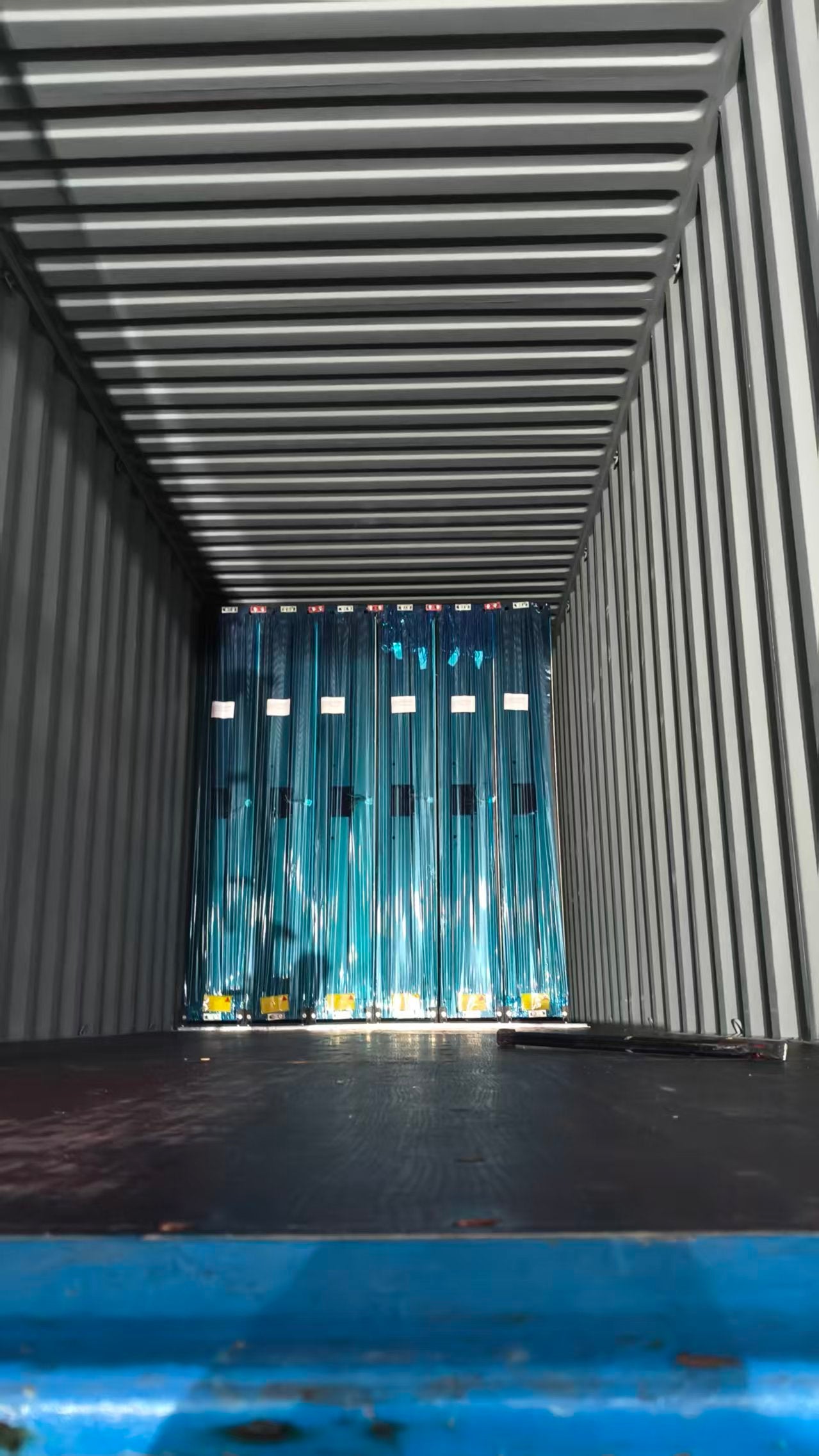 Open shipping container with blue curtains inside
