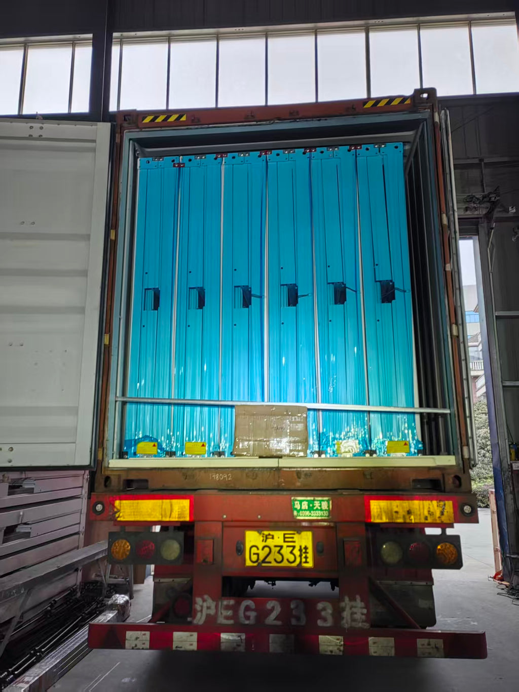 Container with blue interior and visible license plate in a warehouse setting