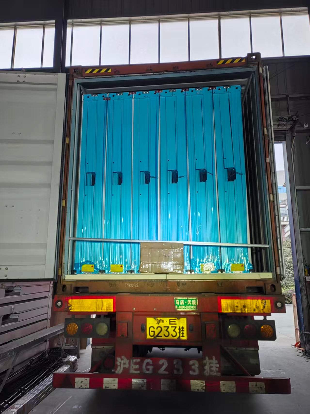 Container with blue interior and visible license plate in a warehouse setting