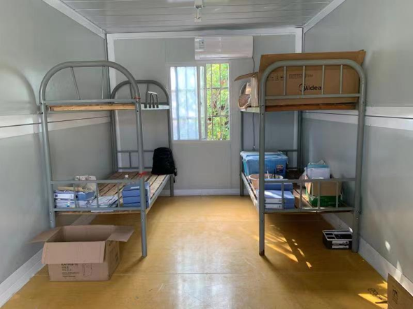 Small room with bunk beds, boxes, and furniture.