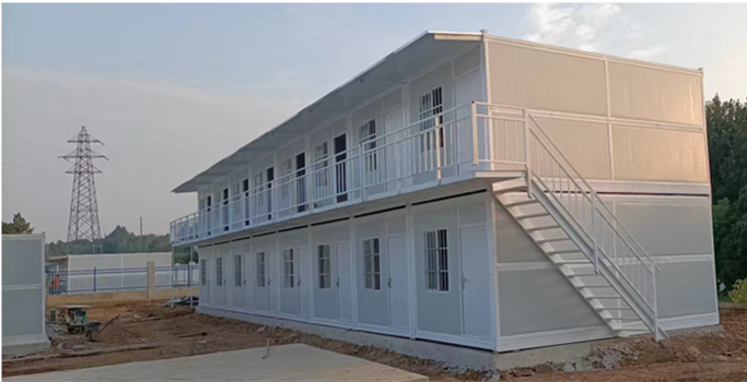 Modular building with balconies and a staircase on a construction site.